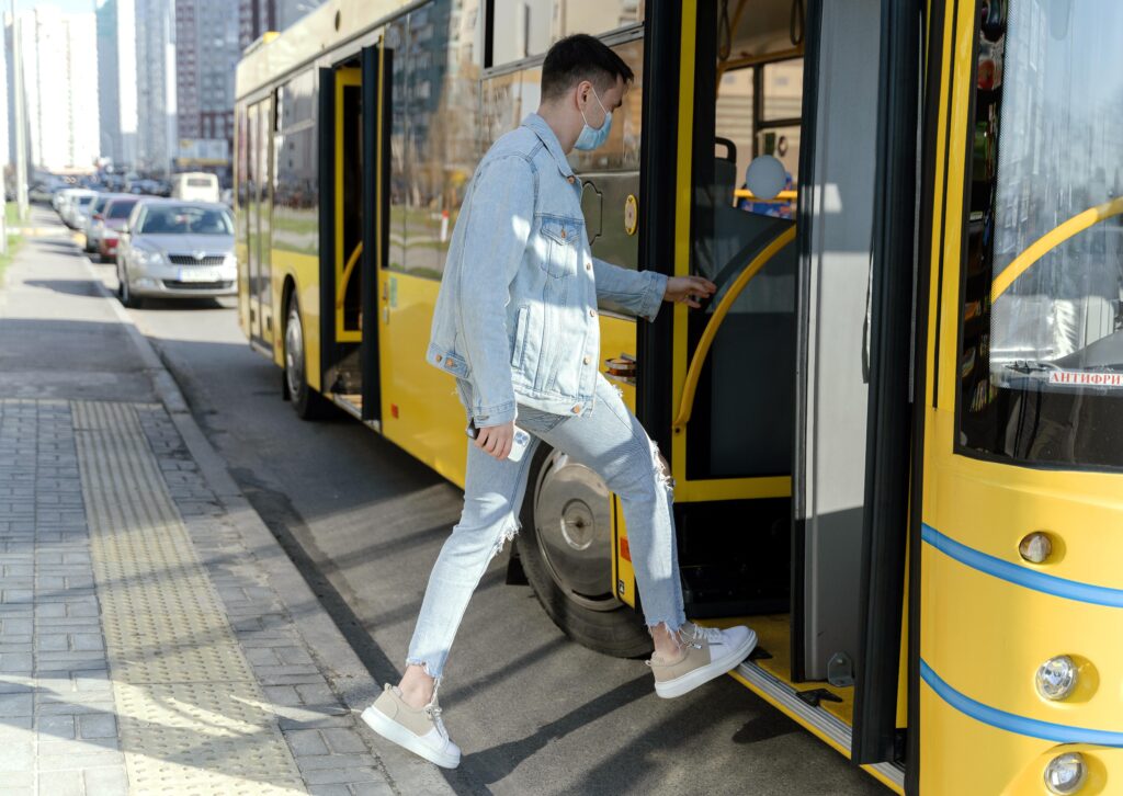 Passenger boarding a yellow intercity bus from Abu Dhabi to Sharjah — public transport travel in UAE.